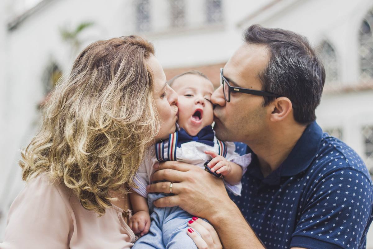Heitor's parents kissing him on both cheeks outside the church