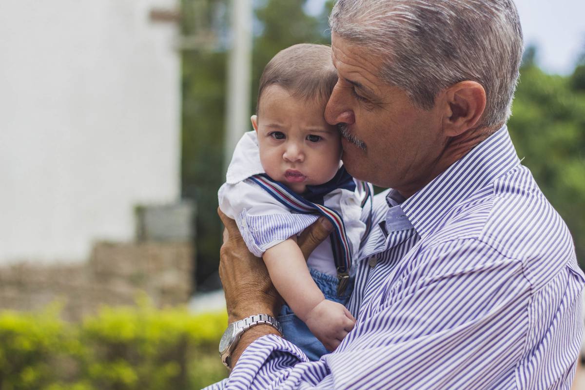 Heitor's grandfather lifting him up outside the church