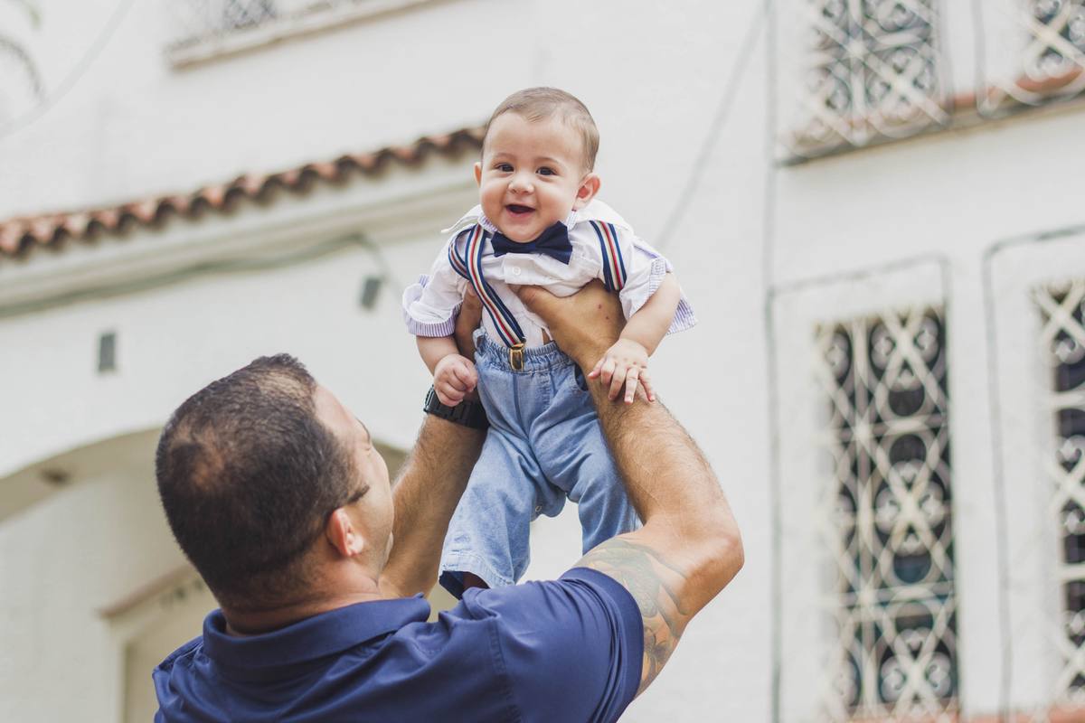 Heitor's father lifting him up before the ceremony