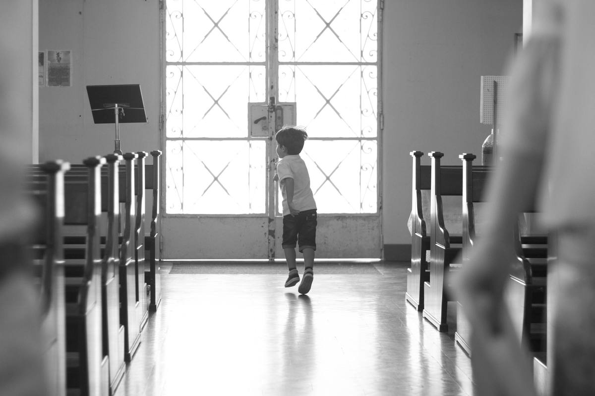 Child running toward the church doors during a baptism