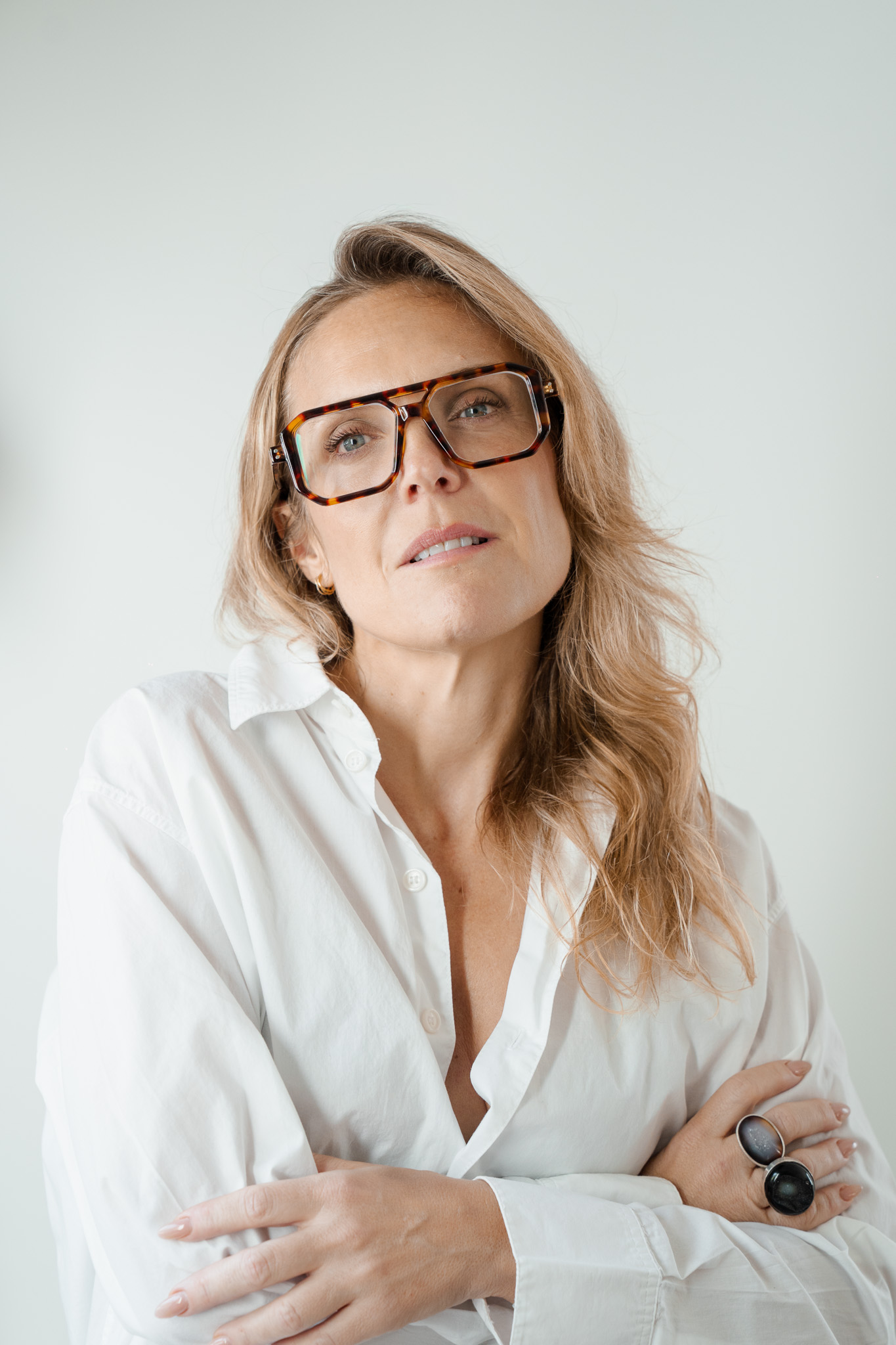 Mireia Martínez looking up, arms crossed, in a white shirt
