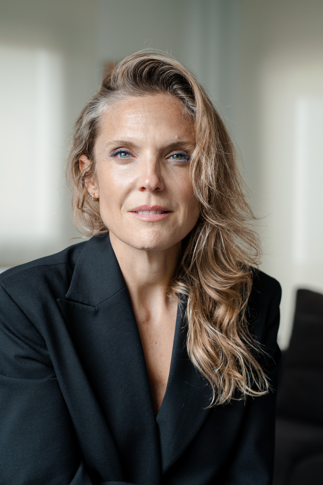 Mireia Martínez seated by a window, black blazer