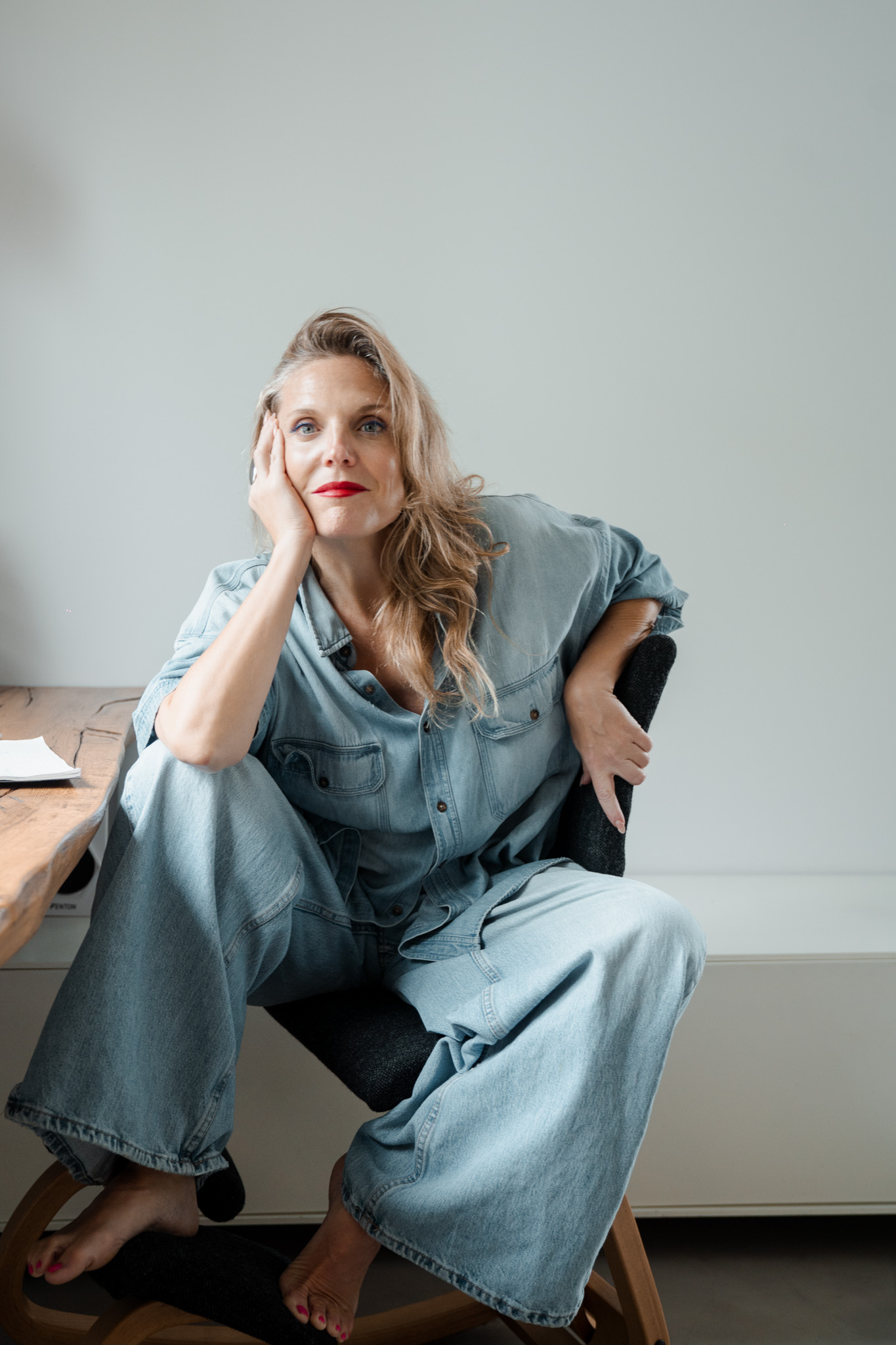 Mireia Martínez seated at a desk in a denim jumpsuit